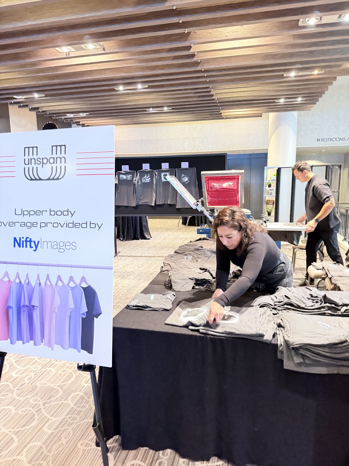 Conference merch table stacked with folded custom event t-shirts