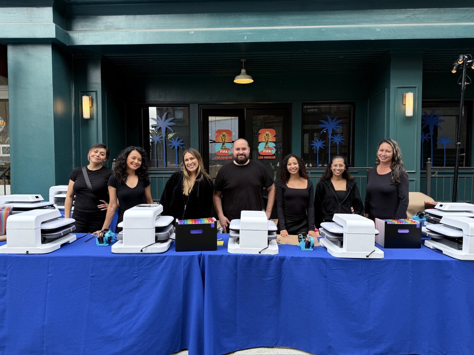 Operator pressing a full-color DTF transfer onto a t-shirt at a live event bar