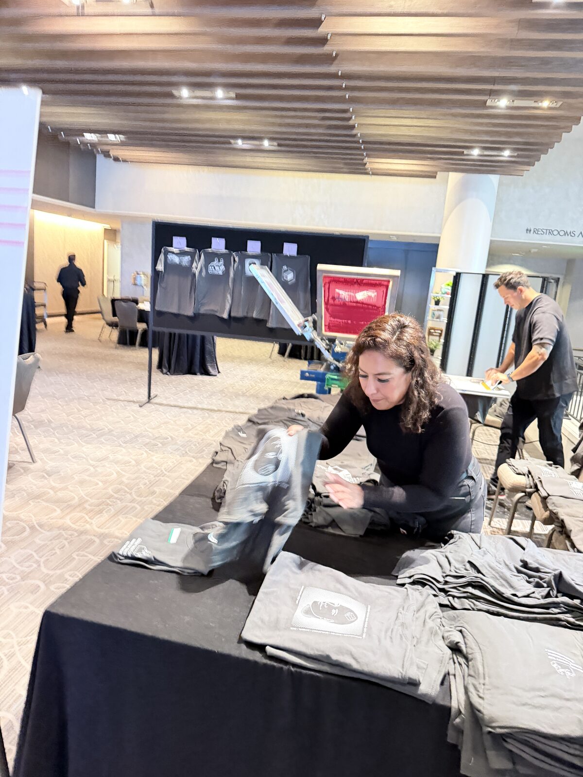Crew folding fresh printed shirts behind the t-shirt bar